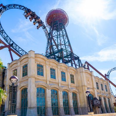 The new Voltron Nevera station building in the bright sunshine, surrounded by green palm trees.